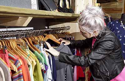 Person looking through clothes in a second hand store