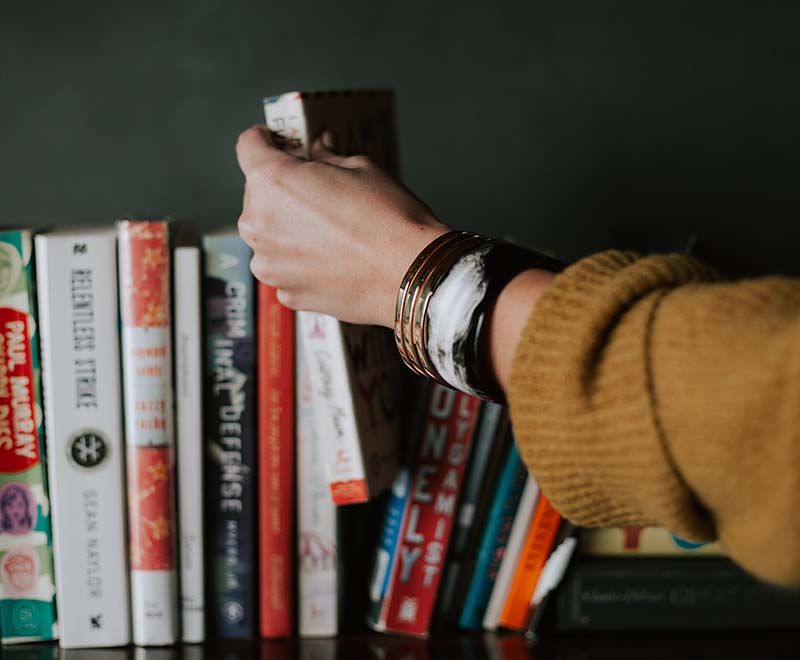 Photo of person picking up a book